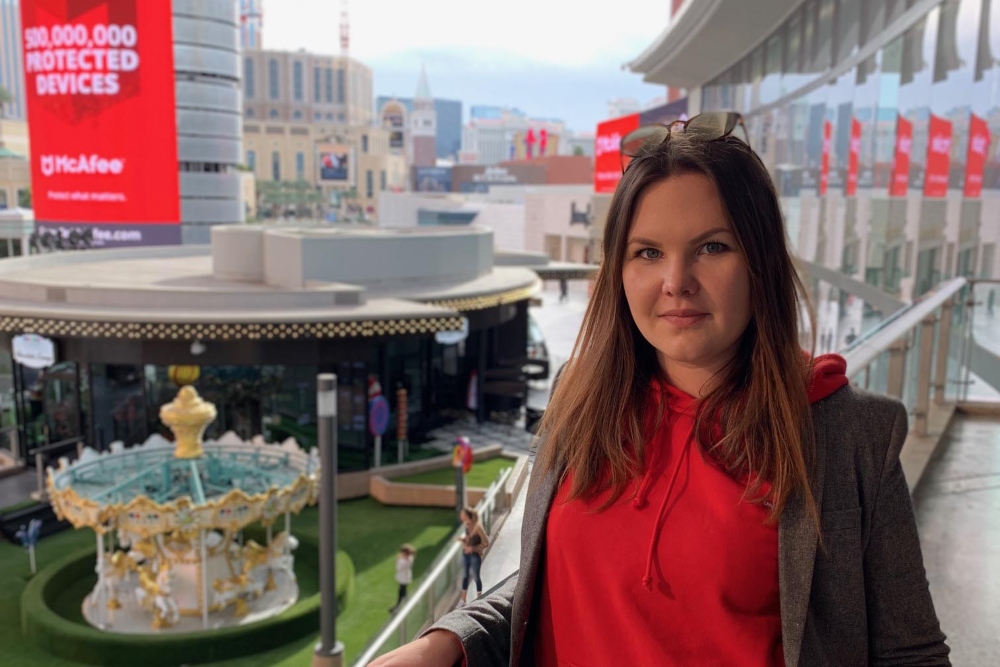Brown haired woman in red top standing on a balcony at Mobile World Congress in Barcelona.