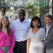 Two women and two men on a street outside a shop.