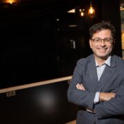 Dark-haired man with arms folded.