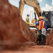 Construction workers digging a trench.