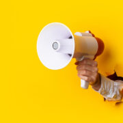 Megaphone breaks through yellow wall.