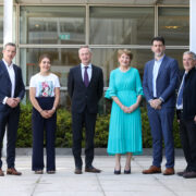 People in front of a glass building.