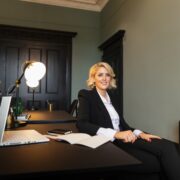 Fair haired woman sitting at a desk.