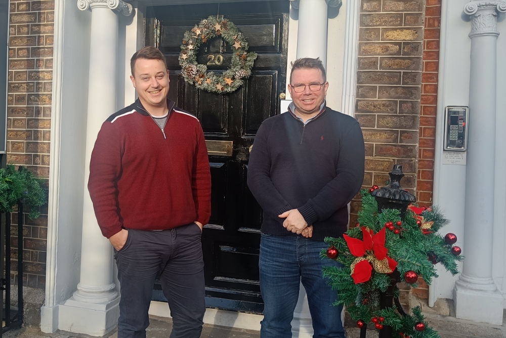 Two men in front of a door.