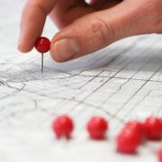 Person putting markers on a map.