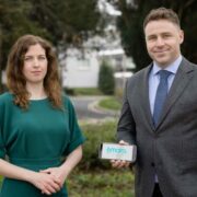 Woman in green dress and man in grey suit.