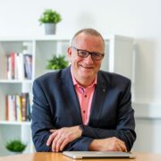 Smiling man in blazer.