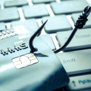 Fishing hook catches bank card to illustrate fraud.