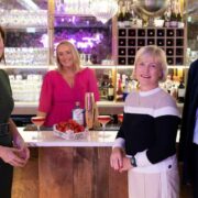 Three women and a man at a table.