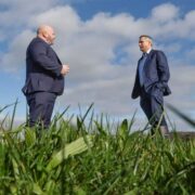 Two men out standing in a field.