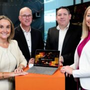 Two men and two women with a laptop.