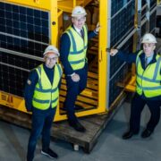 Three men beside a Green Rebel buoy.
