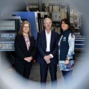 Two women and a man in an industrial setting.