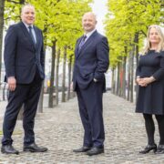 Two men and a woman beside the Liffey in Dublin.