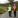 Two men on a country road wearing hi-vis jackets.