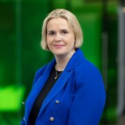 Fair-haired woman in blue coat.