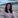 Woman with dark hair sitting by a beach on Achill Island.