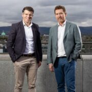 Two men in suits on a rooftop in Dublin.