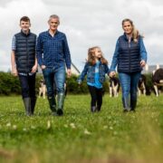 Farming family walking across a field.