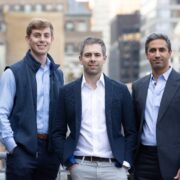 Three men on a balcony in New York.