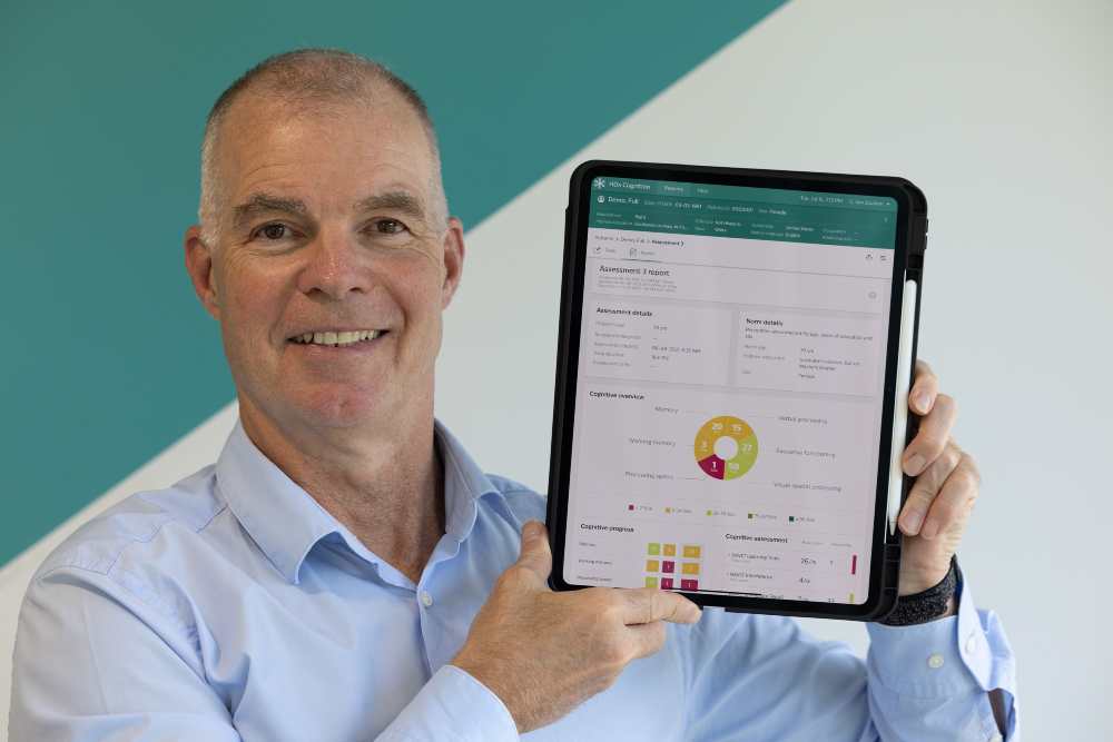 Man in blue shirt holding a tablet computer.