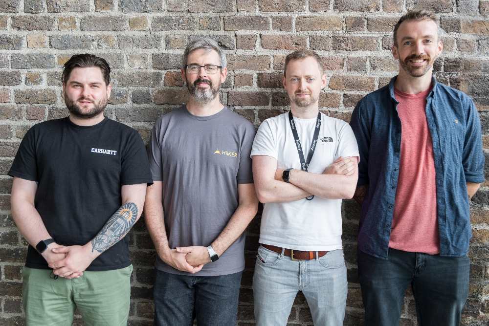 Four men in front of a wall.