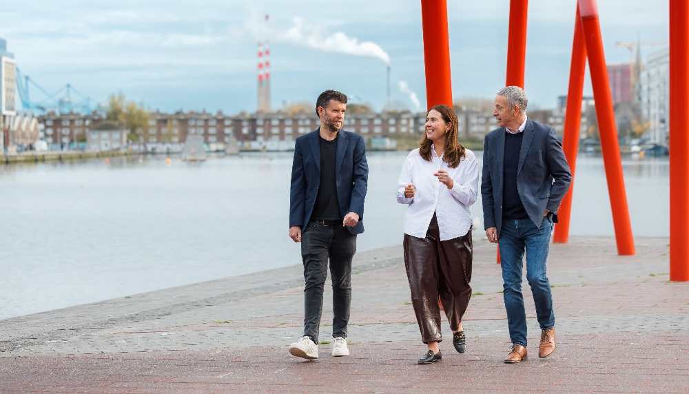 Two men and a woman walking at Silicon Docks in Dublin.