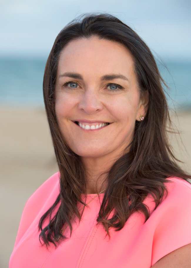 Dark haired woman wearing pink t-shirt.
