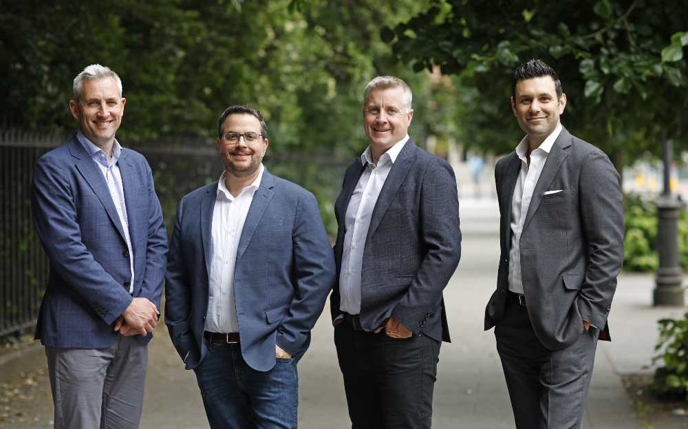 Four men standing on a street.